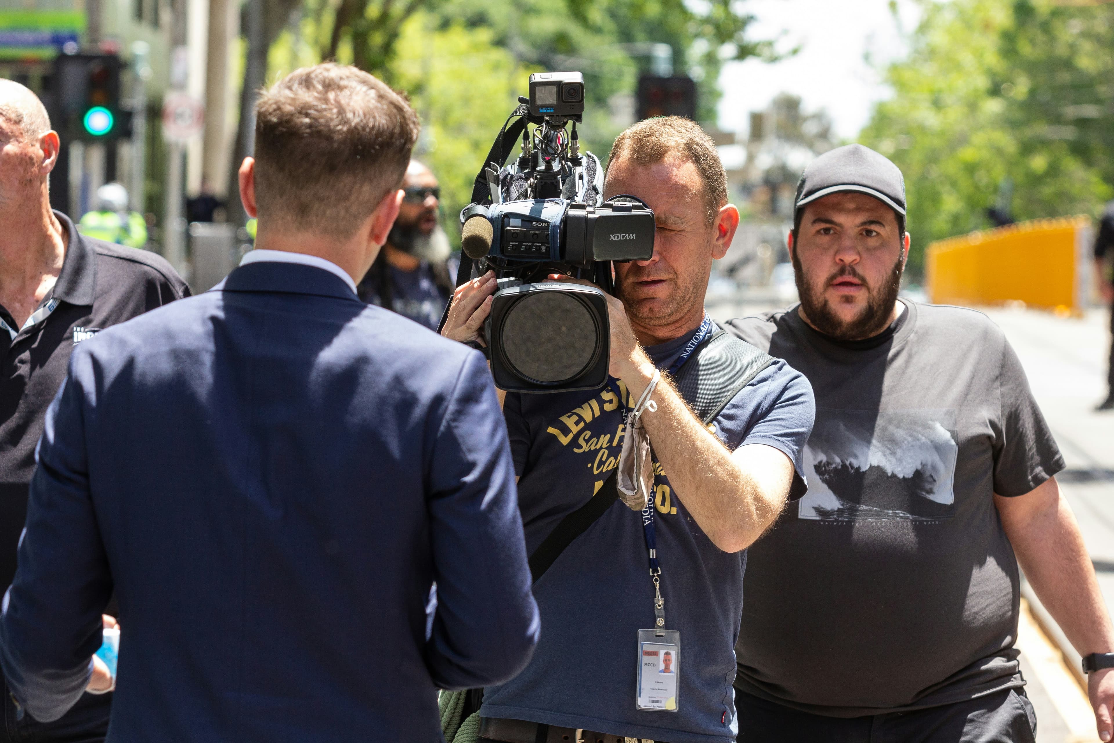 a man holding a camera in front of a group of people